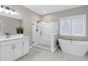 Bright bathroom with a glass-enclosed shower, soaking tub, and white vanity at 213 W Weatherford Dr, Angier, NC 27501