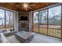 Cozy screened porch with a brick fireplace, comfortable seating, and wooded views at 213 W Weatherford Dr, Angier, NC 27501