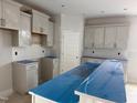 Modern kitchen featuring white cabinets, a center island, and subway tile backsplash at 235 Meadowbark Bnd # 26, Garner, NC 27529