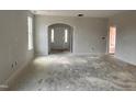 Spacious living room with an arched doorway leading to the entryway in an unfinished home at 235 Meadowbark Bnd # 26, Garner, NC 27529