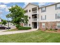 Corner of condo building shows multiple levels with stone accents, surrounded by lush greenery at 3009 Winston Dr # 90, Burlington, NC 27215