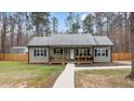 Inviting front exterior featuring a covered porch with wooden railings and a well-manicured lawn at 4082 Old Franklinton Rd, Franklinton, NC 27525