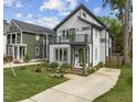 Modern two-story home with gray siding, black trim, a second story balcony, and a beautifully landscaped front yard at 5 Bart St, Raleigh, NC 27610