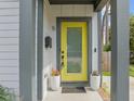 Welcoming front door with a bright yellow color and two potted plants on the porch at 5 Bart St, Raleigh, NC 27610