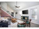 Comfortable living area featuring a ceiling fan, TV, and an open staircase at 5417 Walton Hill Rd, Knightdale, NC 27545