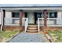 Charming brick and white porch featuring brick columns, white railings and stairs at 5740 Lemon Springs Rd, Sanford, NC 27332