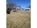 Charming single-story home with gray siding, black shutters, and a well-maintained front yard at 704 Dothan Ave, Burlington, NC 27217