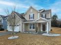 Charming home featuring a two-car garage, a well-manicured lawn, and a welcoming front porch at 800 Tree Green Ln, Wake Forest, NC 27587
