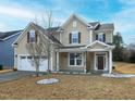Charming home featuring a two-car garage, a well-manicured lawn, and a welcoming front porch at 800 Tree Green Ln, Wake Forest, NC 27587