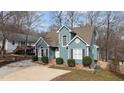 Charming two-story home with a blue exterior, well-manicured landscaping, and a concrete driveway at 886 Drogheda Pl, Wake Forest, NC 27587