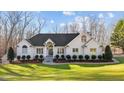 Attractive white brick home with a well-maintained lawn, groomed shrubbery, and a welcoming front entrance at 1002 Pleasant Dr, Mebane, NC 27302