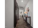 Well-lit hallway featuring wood floors, decorative accents, and sliding barn doors at 1020 Broadlands Way, Graham, NC 27253