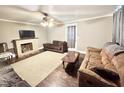 Spacious living room featuring a decorative fireplace, ceiling fan, and neutral tones at 1043 Cavel Chub Lake Rd, Roxboro, NC 27574