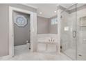 Luxurious bathroom with marble flooring, a soaking tub, and a glass-enclosed shower at 1107 S 2Nd St, Smithfield, NC 27577