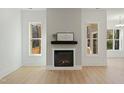 Living room featuring a fireplace, light wood floors, and windows offering natural light at 112 Fort Dr, Louisburg, NC 27549