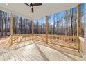 Covered porch with wood railing overlooking a lush, wooded backyard at 112 Fort Dr, Louisburg, NC 27549