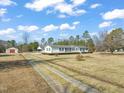 View of the driveway, carport, and home with white siding and green grass at 1304 Nc 96 Hwy S, Zebulon, NC 27597
