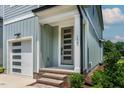 Inviting entrance features a stylish gray door with a brick-paved step and an attached one-car garage at 136 E End Ave # 4, Durham, NC 27703