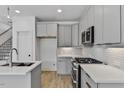 Modern kitchen featuring stainless steel appliances, sleek gray cabinets, and stylish backsplash at 136 E End Ave # 4, Durham, NC 27703