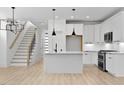 Modern, all-white kitchen with updated appliances, large island, and stylish pendant lighting at 140 E End Ave # 2, Durham, NC 27703
