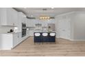 Bright kitchen with white cabinetry, stainless steel appliances, and a navy blue center island at 1400 Gathering Park Cir # 202, Cary, NC 27519