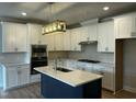 Bright, new kitchen features an island, stainless appliances, and white cabinets at 1400 Gathering Park Cir # 202, Cary, NC 27519