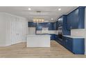 Kitchen featuring an island, stainless steel appliances, blue cabinetry, and stylish light fixture at 1400 Gathering Park Cir # 204, Cary, NC 27519