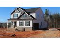 New construction two-story home with light siding, a brick foundation, black trim, and a two-car garage at 1415 Reading Ct # 77Kl, Burlington, NC 27217