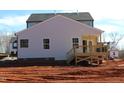 Rear view of a new construction home with a small wooden back deck and light-colored siding at 1415 Reading Ct # 77Kl, Burlington, NC 27217
