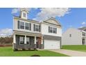 Two story home featuring a two car garage, gray brick accents and contrasting light gray siding at 1705 Post Oak Dr, Haw River, NC 27258