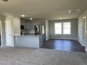 Open concept kitchen with gray cabinets, stainless steel appliances, granite countertops, and vinyl flooring at 181 Pate Landing Dr, Selma, NC 27576