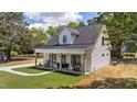 Charming two-story white home featuring a welcoming front porch and freshly manicured lawn at 412 N Green St, Selma, NC 27576