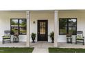 Charming front porch with a black front door flanked by rocking chairs and planters at 412 N Green St, Selma, NC 27576