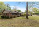 A charming brick home features classic architecture with a lush lawn and a convenient carport for parking at 714 W J St, Erwin, NC 28339