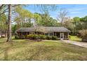 Charming brick home features manicured landscaping, a well-maintained lawn, and an inviting screened-in porch at 714 W J St, Erwin, NC 28339