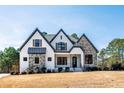 Beautiful new construction home featuring a combination of stone and white siding with black trim at 8621 Bishop Pine Ln, Wake Forest, NC 27587