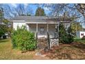 Charming front entrance with concrete steps and covered porch, framed by lush greenery at 110 W Elm St, Nashville, NC 27856