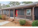 Cozy front porch with brick steps, decorative railing, and a striking red front door at 1729 Augustus Dr, Rocky Mount, NC 27801