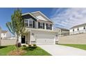 Charming two-story home featuring a gray exterior, black shutters, and a spacious two-car garage at 266 Hanging Elm Ln, Fuquay Varina, NC 27526