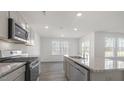 Bright kitchen with stainless steel appliances, granite counters, recessed lights, and a double sink at 433 Citron St, Sanford, NC 27332
