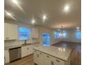 Open-concept kitchen with granite island flows into a spacious living area with multiple windows at 544 John Stark Dr, Fuquay Varina, NC 27526