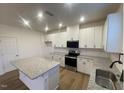 Well-lit kitchen boasts white cabinets, stainless steel appliances, and granite countertops at 544 John Stark Dr, Fuquay Varina, NC 27526