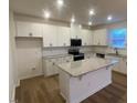 Bright kitchen featuring white cabinets, granite countertops, and a spacious center island at 544 John Stark Dr, Fuquay Varina, NC 27526