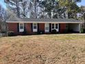 Charming one-story brick home with an attached carport and well-maintained front yard and established trees at 613 Sexton Ave, Zebulon, NC 27597