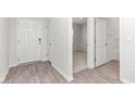 A welcoming entryway featuring durable wood-look floors and white trim details on the walls and doors at 865 Forth Ct # 145, Gibsonville, NC 27249