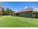Expansive green backyard featuring lush grass, mature trees, and covered patio at 1008 Octans Way, Wendell, NC 27591