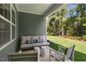 Covered patio with comfortable seating overlooking the well-maintained backyard and greenery at 1008 Octans Way, Wendell, NC 27591