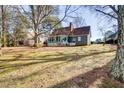 Spacious backyard features mature trees, grassy area, and a sunroom addition, providing ample space for outdoor activities at 103 Allison Way, Cary, NC 27511