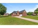 Beautiful all-brick home with a well-maintained lawn and a long driveway leading to the garage at 105 Pinecrest Dr, Angier, NC 27501