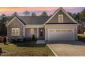 Charming home with a stone facade, a welcoming front porch, and an attached two car garage at 110 Lilac Dr, Franklinton, NC 27525